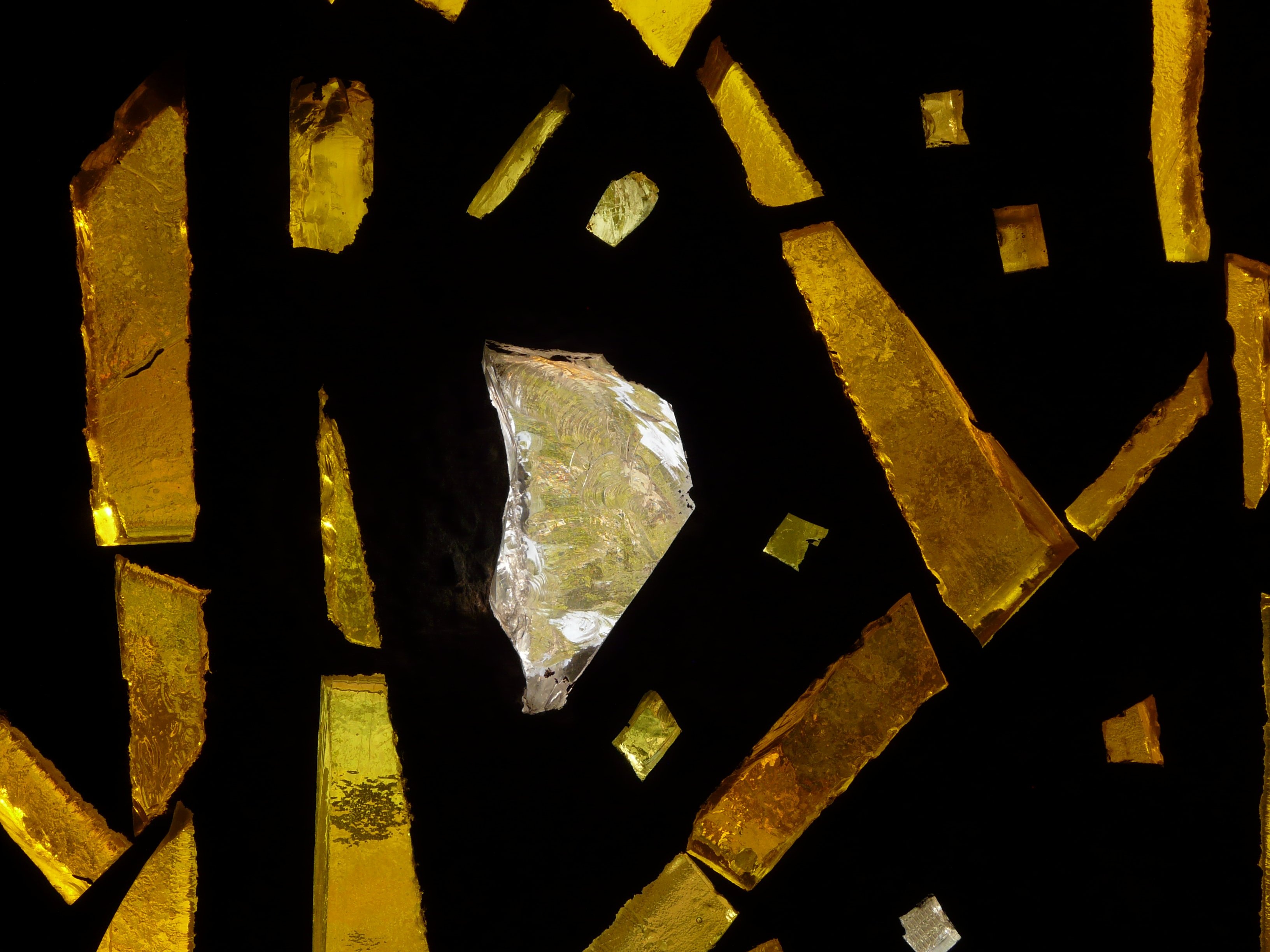 Golden Tiffany-style glass fragments illuminated against dark background